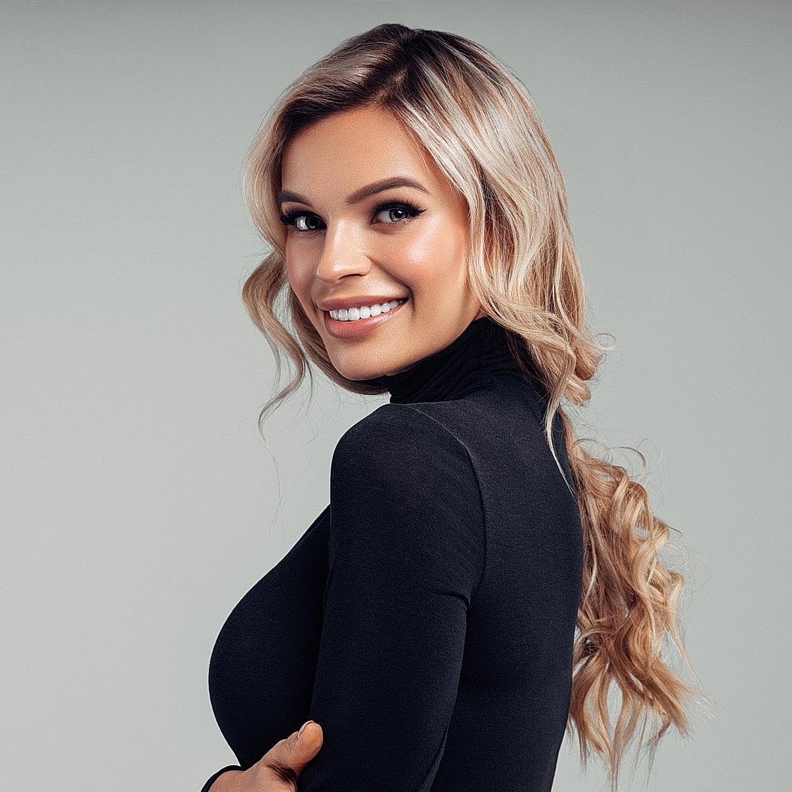 Smiling woman with long blonde hair in black top.