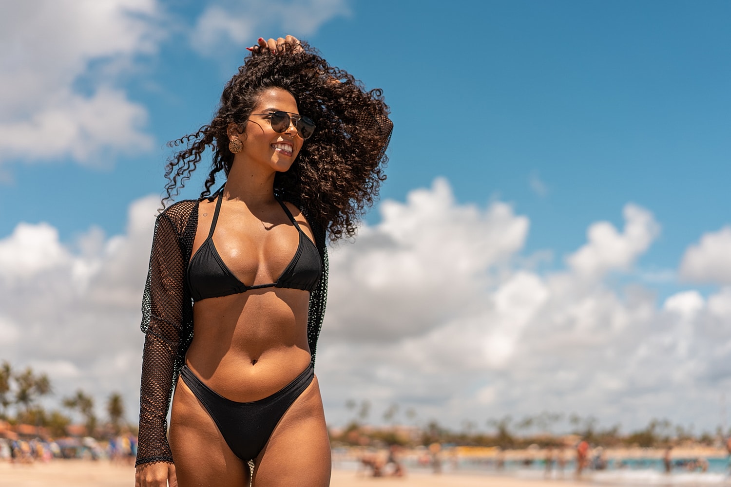 Woman in black bikini enjoying beach day.